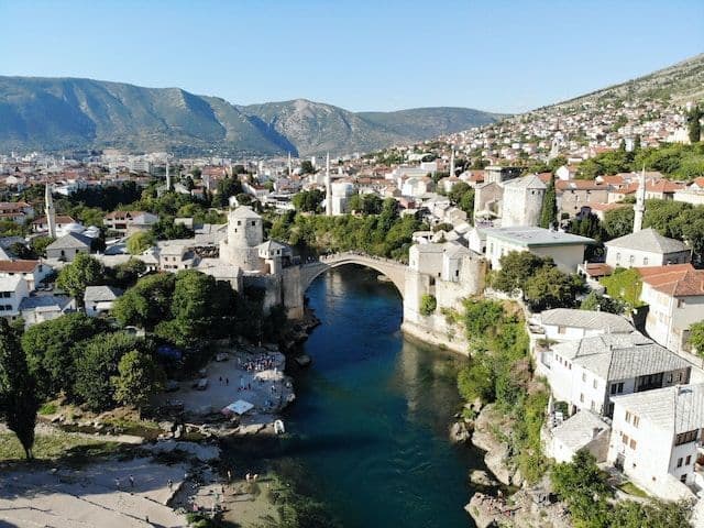 Old Bridge of Mostar, river, and mountains
